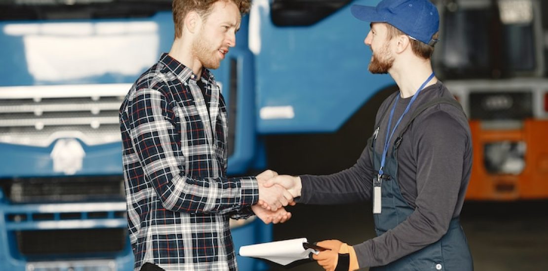 two-guys-talking-about-work-work-garage-near-truck-transfer-documents-with-goods_1157-46506